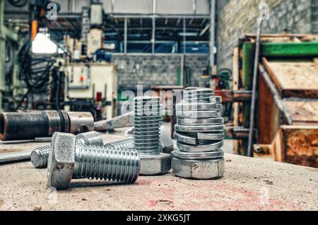 Set of bolts on blurred workshop background. Expendable hardware. Assortment steel screws close-up Stock Photo