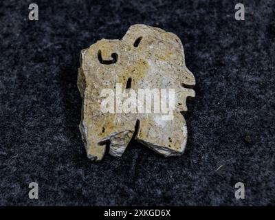 (240723) -- CHENGDU, July 23, 2024 (Xinhua) -- This photo taken on July 10, 2024 shows a side-profile human figure carved on jade discovered at the Sanxingdui Ruins site in Guanghan City, southwest China's Sichuan Province. Archaeological authorities have recently unveiled groundbreaking discoveries, including a jade and stone artifact 'workshop' dating back over 3,400 years, at the legendary Sanxingdui Ruins site. The new finds offer vital insights into the origins of various precious cultural relics and highlight the remarkable achievements of ancient Chinese civilization. (Xinhua/Wang Xi) Stock Photo