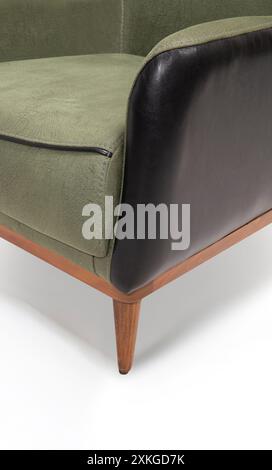 Close-up of green armchair with black leather sides, showing detail. Stock Photo