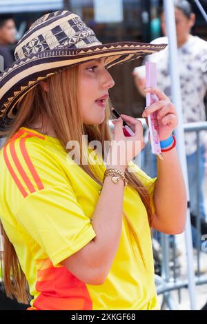 An attractive woman vendor wearing a Columbia soccer jersey at an outdoor rally on the day of the Copa America 2024 finals. In Jackson Heights Queens. Stock Photo