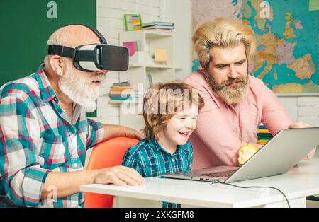 Three generations of men having fun together. GrandFather, father and son playing computer games at home. Parenting childhood values weekend. Stock Photo