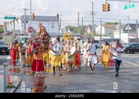 A group of devout Hindus carry statues of deities proceed to the Arya Spiritual Grounds for the Thimithi ritual of walking on hot coals. In Queens, NY. Stock Photo