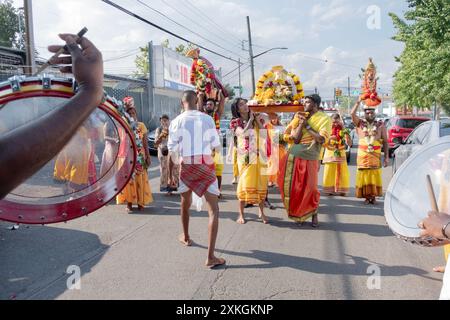 Devout Hindu worshippers march to the Arya Spiritual Grounds for the Thimithi ritual carry a statue of goddess Kali. In Queens, New York. Stock Photo