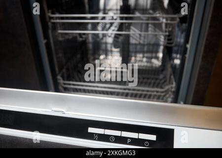 Dishwasher control panel closeup. Mode program timer knobs on control panel of dishwasher machine selected focus over out of focus background. Stock Photo
