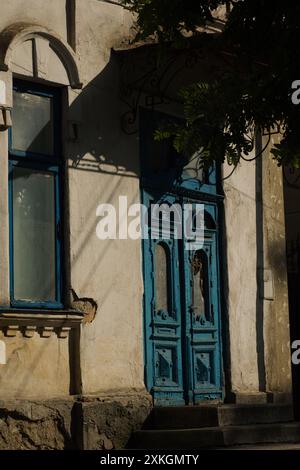 blue old wooden door in an old house on a sunny day Stock Photo