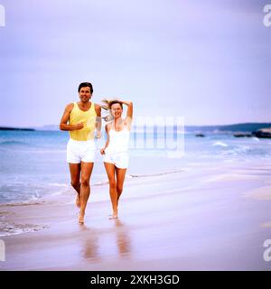 Young couple jogging on a beach. Stock Photo