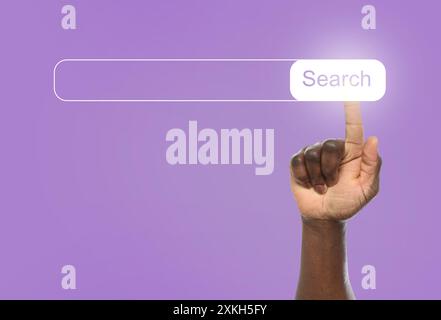 Man using search bar on virtual screen against violet background, closeup Stock Photo