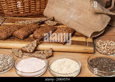 Dark bread with additives laid out on the table in petri bowls: sunflower seeds, sesame, puffed rice, cumin. High quality photo Stock Photo