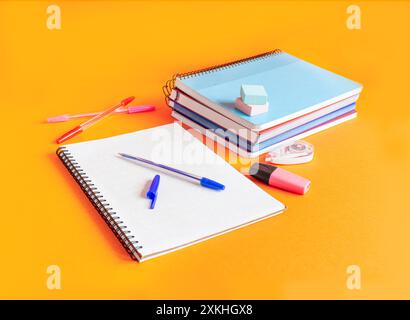 Still life with an orange background of supplies for the long-awaited return to class. Stock Photo