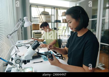 Colleagues Repairing Gadgets In Workshop Stock Photo