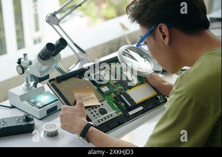 Repairman Using Magnifier At His Work Stock Photo