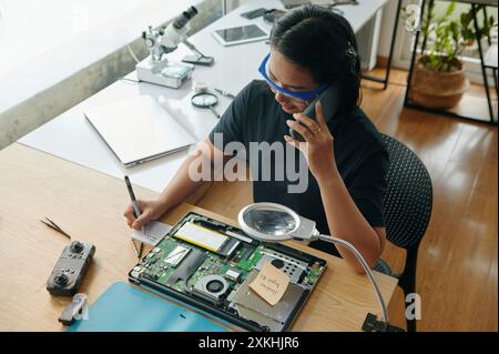 Master Making Notes During Repair Stock Photo