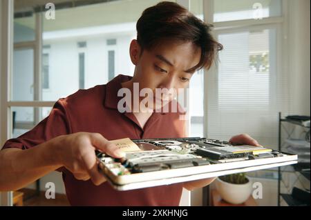 Engineer Working With Broken Laptop Stock Photo