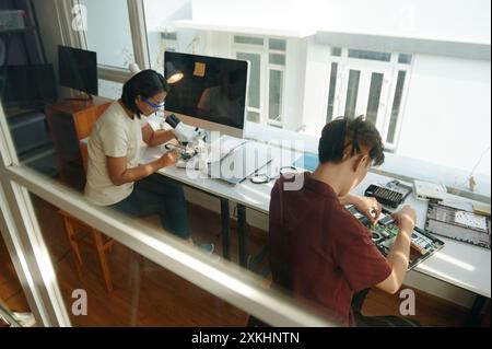 Colleagues Repairing Gadgets In Workshop Stock Photo