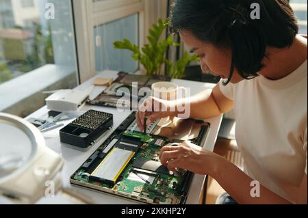 Woman Using Screwdriver In Repair Of Laptop Stock Photo