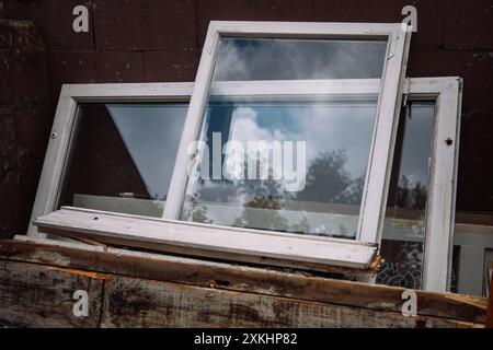 Construction waste for disposal. Heap of old wooden window frames with glass outdoors. Renovation and reconstruction concept. Replacement of windows Stock Photo