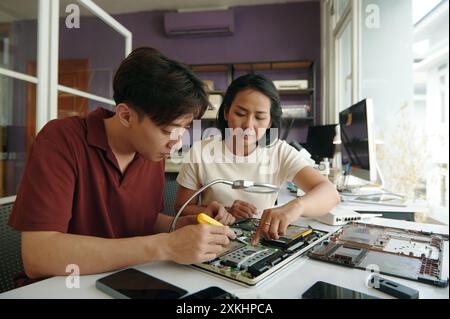 Colleagues Repairing Laptop In Team Stock Photo