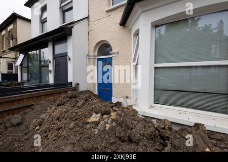 Builders leave a homeowners front garden overloaded with topsoil making it unable to leave via their front door, England, UK Stock Photo