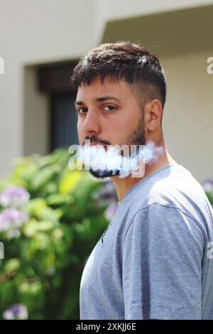 A vivid image featuring a young man smoking a joint on a sunny day in the city of Zurich. Ideal for themes related to urban culture, relaxation, and l Stock Photo