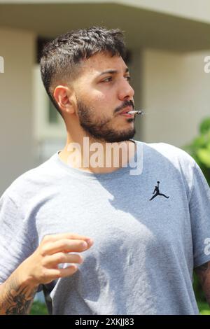 A vivid image featuring a young man smoking a joint on a sunny day in the city of Zurich. Ideal for themes related to urban culture, relaxation, and l Stock Photo