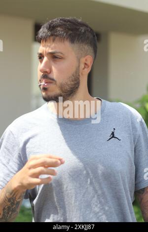 A vivid image featuring a young man smoking a joint on a sunny day in the city of Zurich. Ideal for themes related to urban culture, relaxation, and l Stock Photo