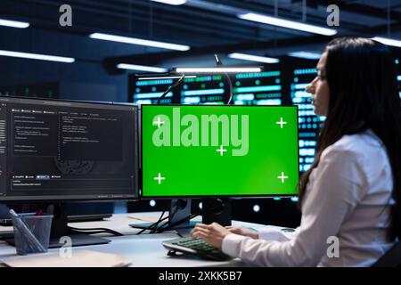 Engineer in server hub using green screen PC to repair equipment storing datasets. Professional using mockup computer to do debugging on rigs doing computational operations Stock Photo