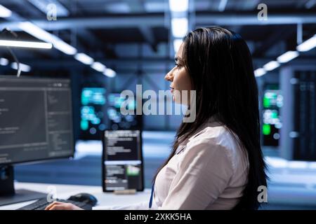 Admin in server hub checking recovery plan, monitoring data center energy consumption across components, making sure sensors are functioning optimally, doing routine disk checks, close up Stock Photo