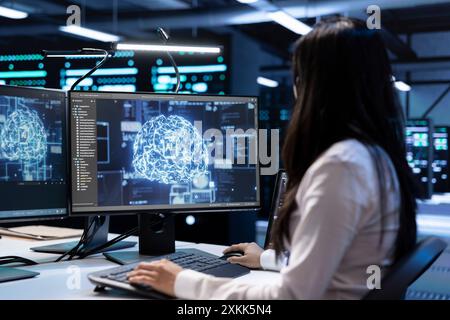 Engineer working in data center providing computing resources needed for artificial intelligence to process massive datasets for training. Woman in server room storing data used for machine learning Stock Photo