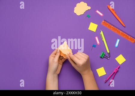 Female hands holding sticky note on purple background Stock Photo