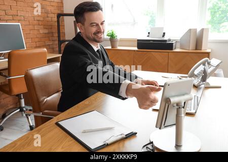 Young businessman unlocking tablet computer at desk in office Stock Photo