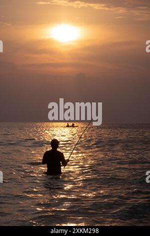 04.11.2023, Indonesia, Lombok, Senggigi - Silhouette: Man fishing in the sea at sunset. 00S231104D221CAROEX.JPG [MODEL RELEASE: NO, PROPERTY RELEASE: Stock Photo