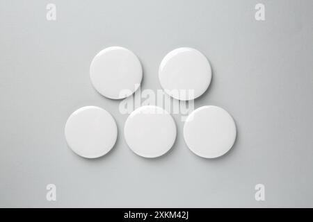 Blank white button badges on grey background, top view. Mockup for design Stock Photo