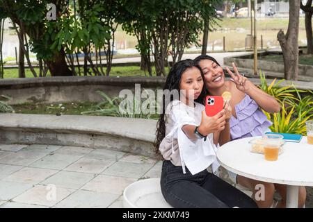 Two young Latina women taking a selfie outdoors Stock Photo