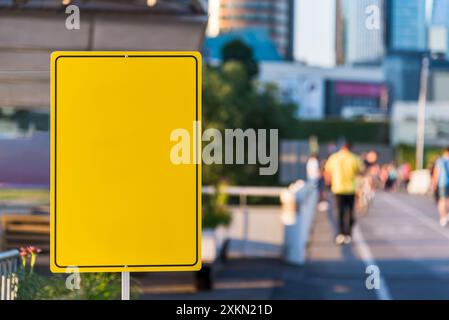 Mockup Of Yellow Empty Metal Street Sign In City Panorama With Walking People Stock Photo
