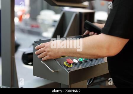 Band saw machine operator at the control console. Selective focus. Stock Photo