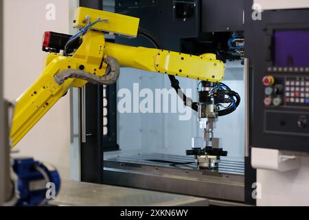 Collaborative robot loading workpieces into CNC machining center. Robotic work cell. Selective focus. Stock Photo