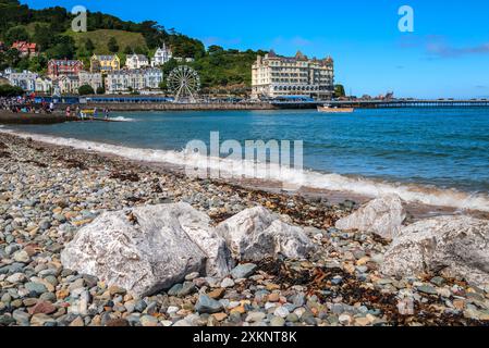 Llandudno bay shingle shore with the Grand Hotel and pier nestling at the foot of the Great Orme. Stock Photo
