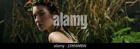 A woman wearing a floral crown poses in a swamp. Stock Photo