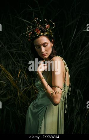 A woman in a floral crown and green dress stands near a swamp. Stock Photo