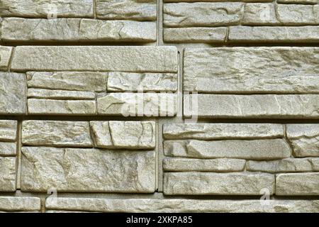 Close up front view of wall covered from finishing beige decorative brick panels Stock Photo