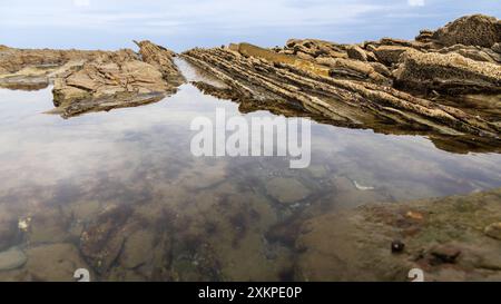 Smooth calm sea water and flysch formations. Sakoneta Flysch, Deba, Gipuzkoa, Basque Country, Spain. Stock Photo