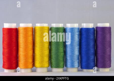 Rainbow colour sewing threads on white background Stock Photo