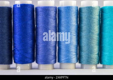 An assortment of blue sewing threads on white background Stock Photo