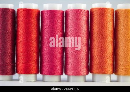 An assortment of red sewing threads on white background Stock Photo