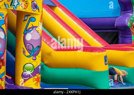 young child on a brightly coloured inflatable bouncy castle Stock Photo