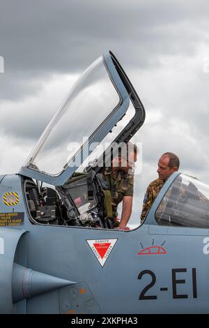 fast jert fighter pilot talking to an engineer looking into the cockpit under the canopy of a fast fighter jet warplane at riat in raf fairford Stock Photo