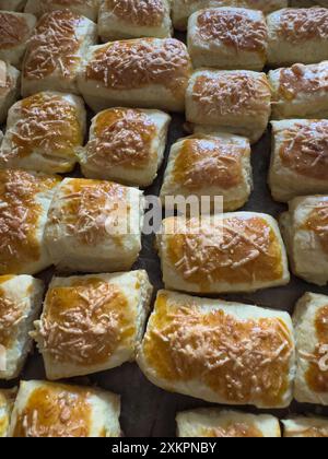 Freshly baked bread rolls with a golden crust and cheese topping Stock Photo