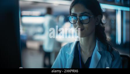 Portrait of a Professional Female Specialist Using Computer at Work in Research and Development Agency. Young Multiethnic Engineer, Developer or Scientist Working in Development Technology Office Stock Photo
