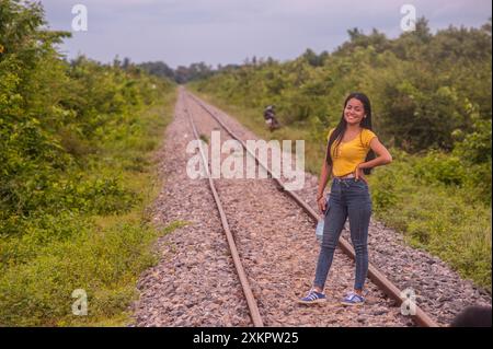 A Cambodian woman poses for a photo on the tracks of the Bamboo Train during the COVID - 19 pandemic. Battambang Province, Cambodia. © Kraig Lieb Stock Photo