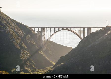 Arch bridge along a road running along the spectacular coast of central California at sunset in autumn Stock Photo